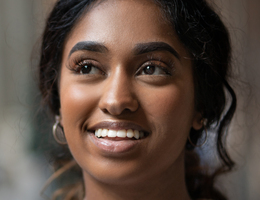 Close-up of a woman’s face. She is smiling.