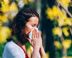 A woman blows her nose.