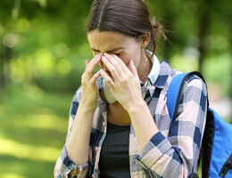 A woman puts the tips of her fingers to the frown lines between her eyes.