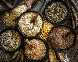 Bowls and scoops of a variety of whole grains.